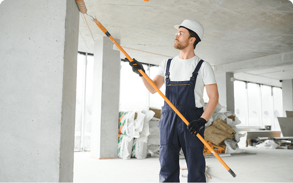 Man in overalls painting interior ceiling
