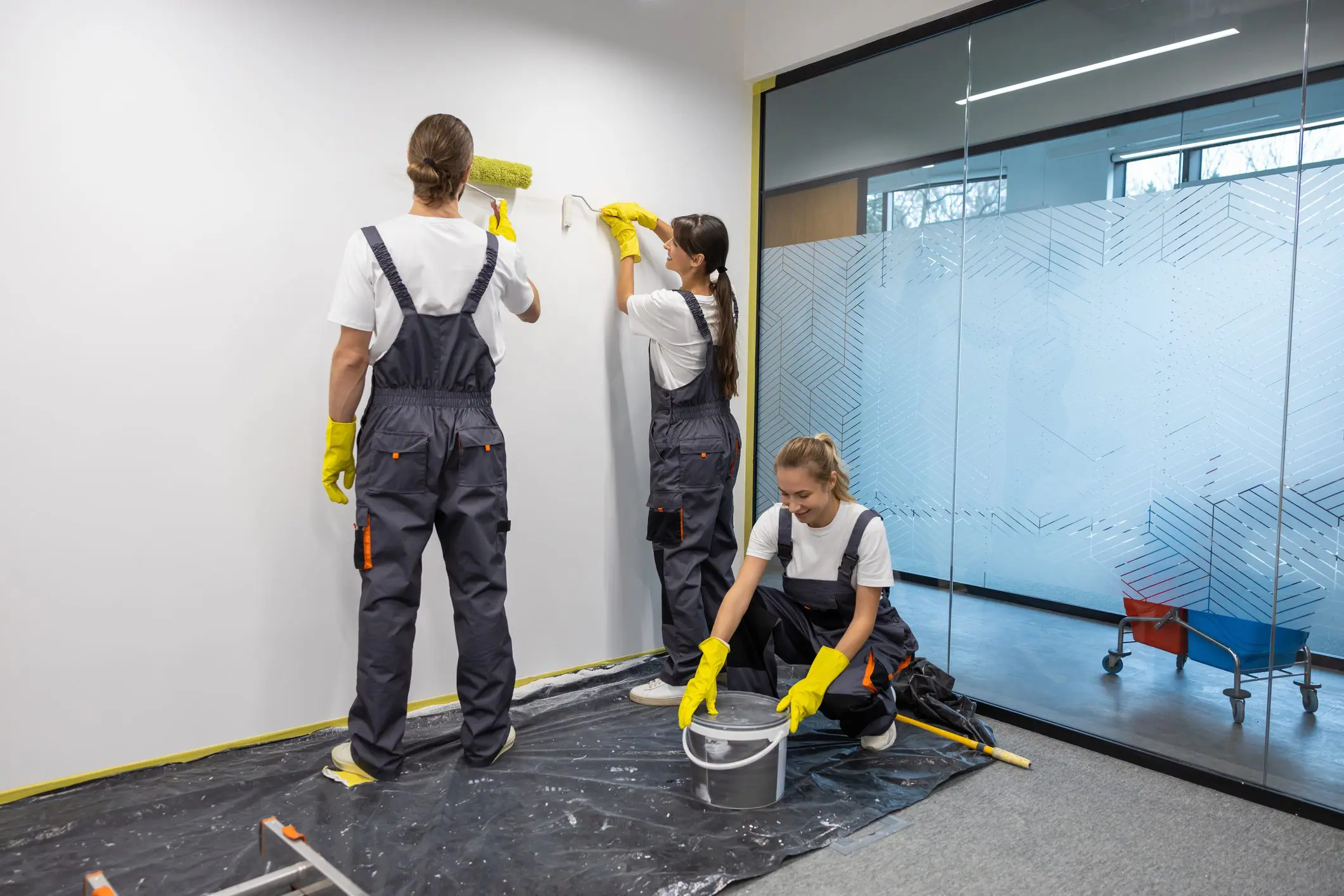 Workers painting with rollers and brushes