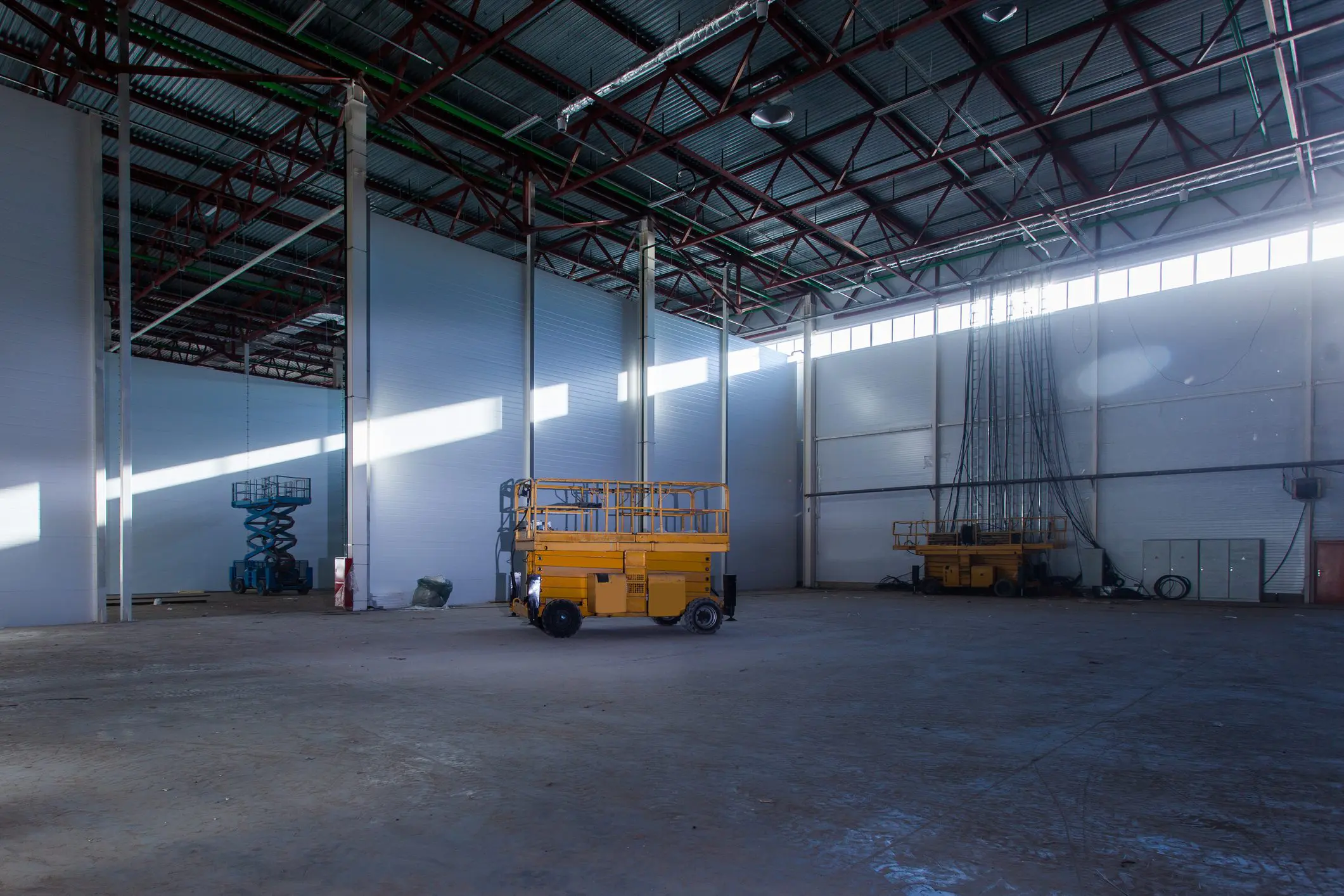 Spacious warehouse with yellow scissor lift