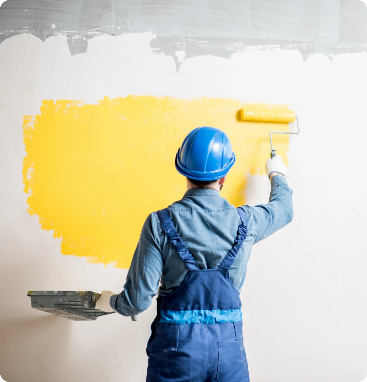 Painting wall with yellow paint roller